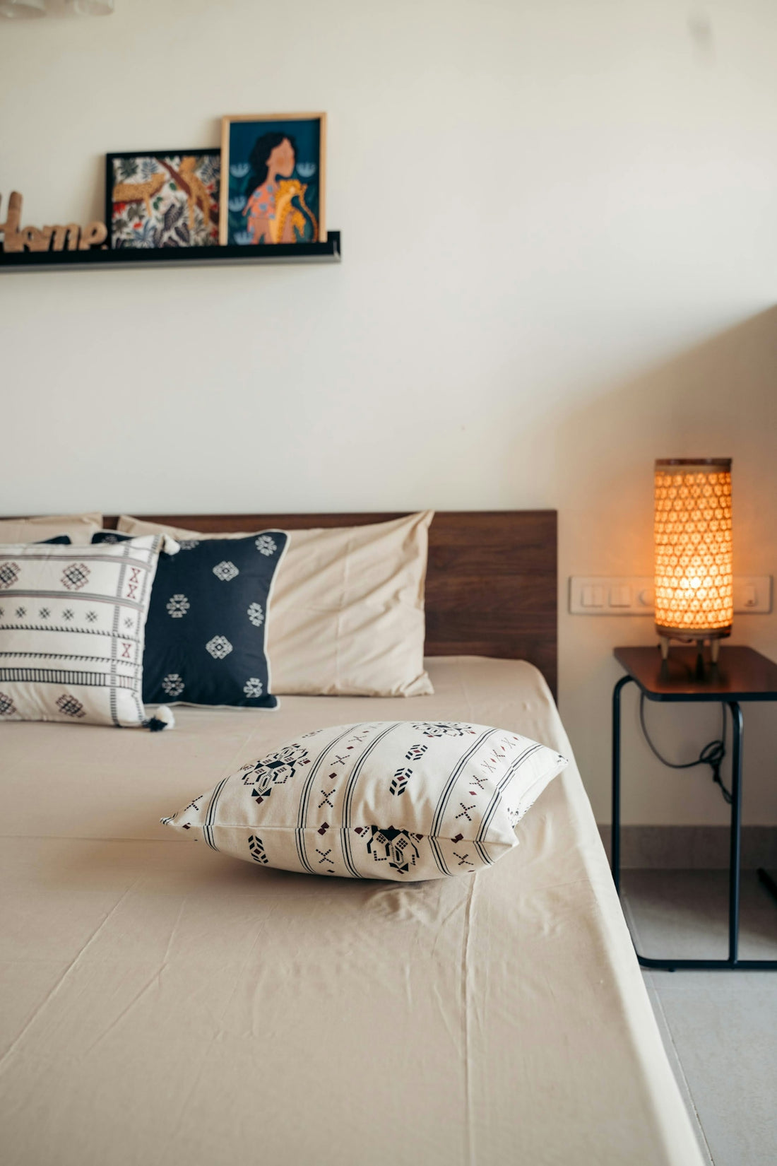 A cozy bedroom with decorative pillows and lamp